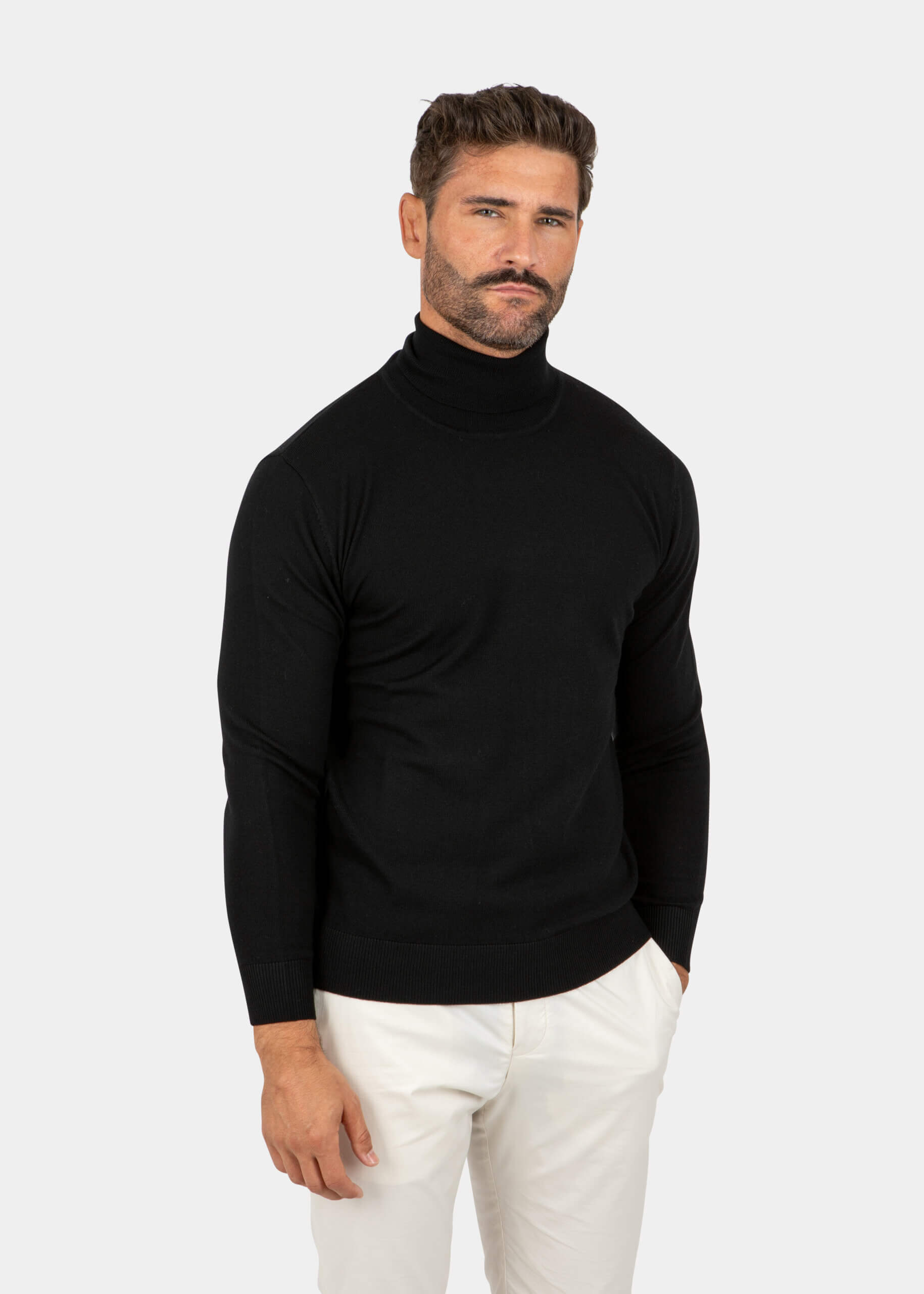 Model wearing a black Merino wool turtleneck sweater, front view.