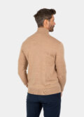 Model wearing a khaki Merino wool turtleneck sweater, back view.