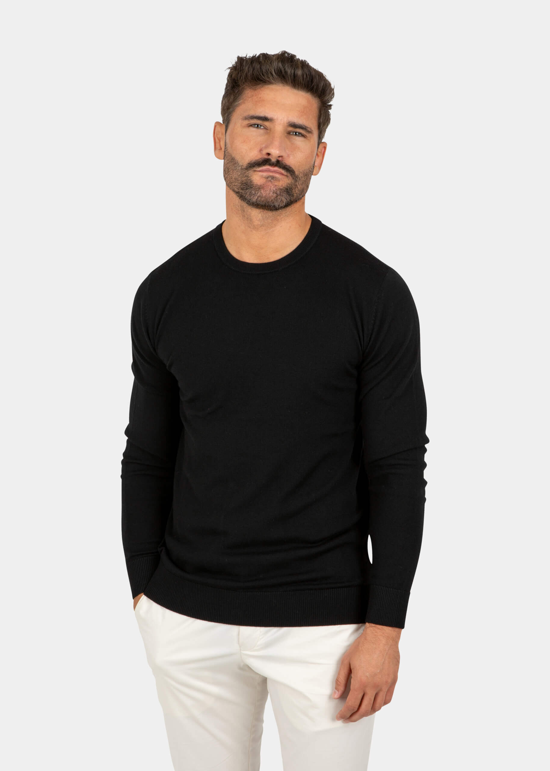Model wearing a black Merino wool crew neck sweater, front view.