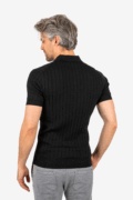 Back view of men’s ribbed polo in black, worn by model