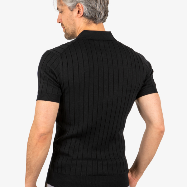 Back view of men’s ribbed polo in black, worn by model